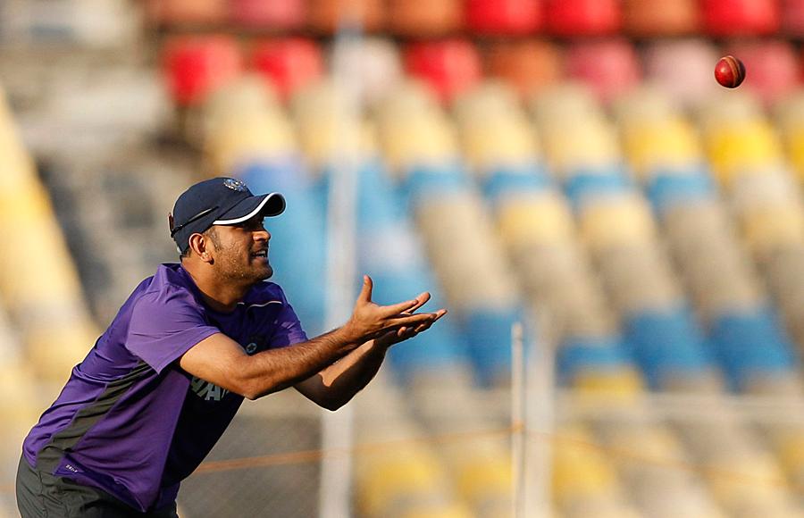 Dhoni prepares to catch during a practice session