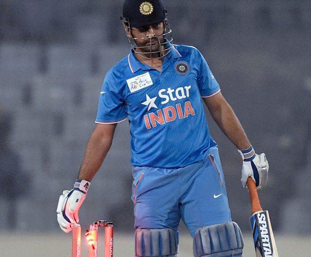 Mahendra Singh Dhoni removes one of the two bails from the stumps India
