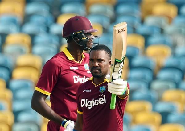 West Indies cricketer Darren Bravo celebrates after scoring his century as team captain Jason Holder looks on during the 9th One Day International match of the Tri-nation Series between South Africa and West Indies at the Kensington Oval stadium in Bridgetown on June 24, 2016. / AFP / JEWEL SAMAD (Photo credit should read JEWEL SAMAD/AFP/Getty Images)