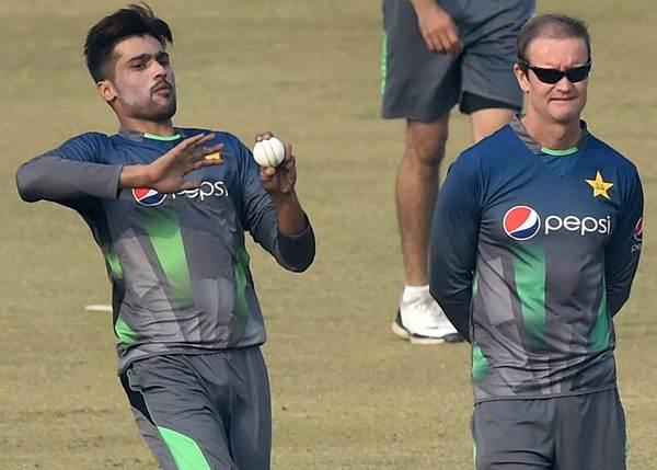 Pakistan cricket batting coach Grant Flower (R) watches as cricketer Mohammad Amir bowls during a team practice session at a camp ahead of the New Zealand tour, in Lahore on January 2, 2016. Paceman Mohammad Amir, who served a prison term for spot-fixing, said he was ready to respond to his critics with wickets -- and love -- after being selected for Pakistan's limited-overs tour of New Zealand. AFP PHOTO / Arif ALI / AFP / Arif Ali (Photo credit should read ARIF ALI/AFP/Getty Images)