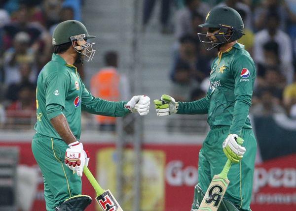 Pakistan's batsmen Shoaib Malik (R) and Sarfraz Ahmed gesture to each other during the second T20I match between Pakistan and the West Indies at the Dubai International Cricket Stadium on September 24, 2016. / AFP / KARIM SAHIB (Photo credit should read KARIM SAHIB/AFP/Getty Images)