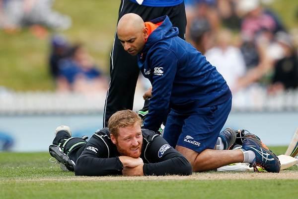 Medics check the injury to Martin Guptill of New Zealand