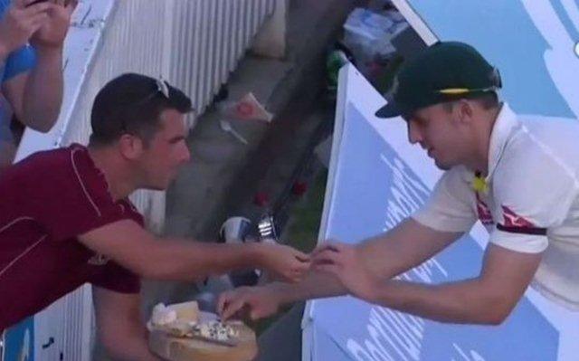 A fan offers food to Mitchell Marsh